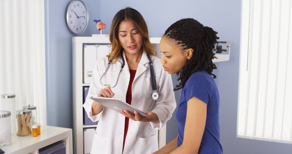 african american patient explaining issues to asian doctor