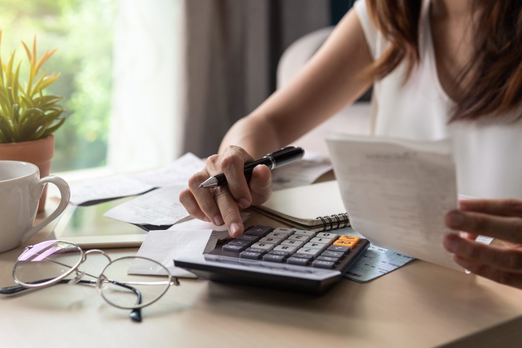 young woman checking bills taxes and calculating expenses