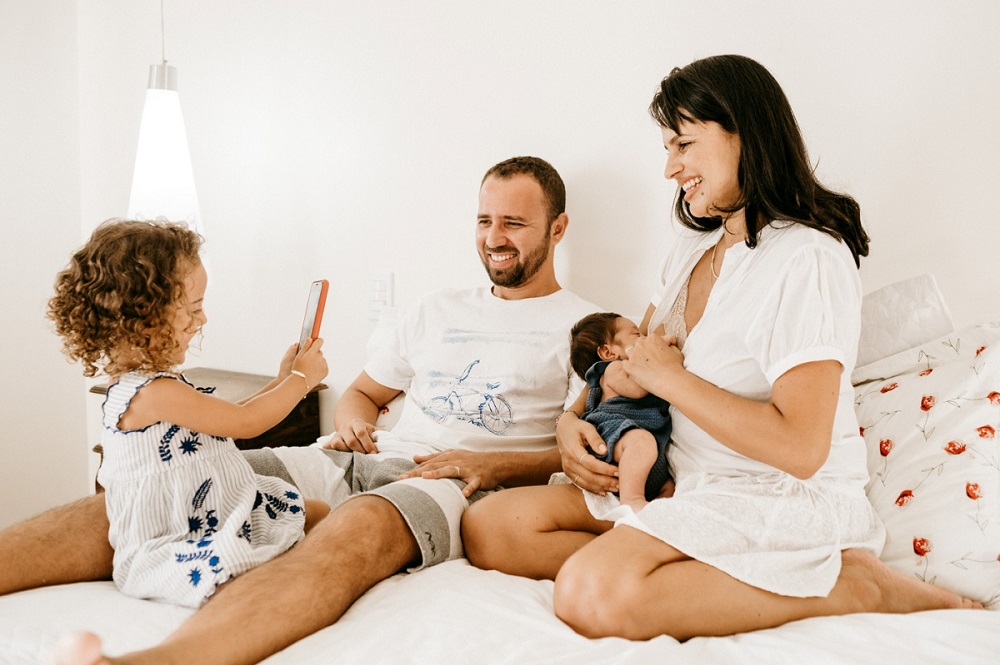 Cheerful family having fun with their kids on the bed.