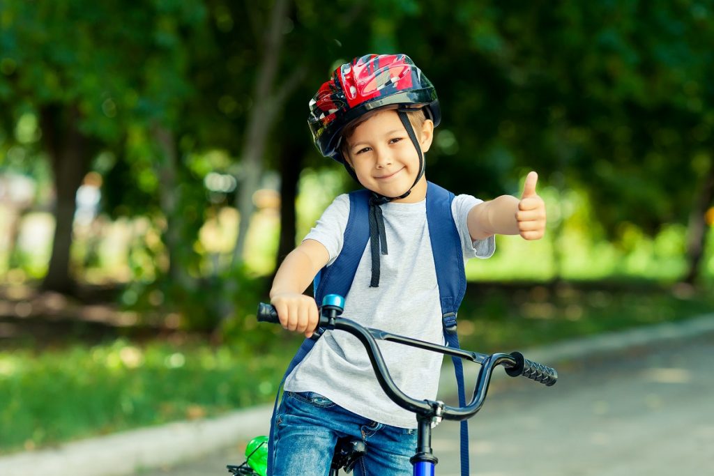 Kid shows the thumbs up on bicycle