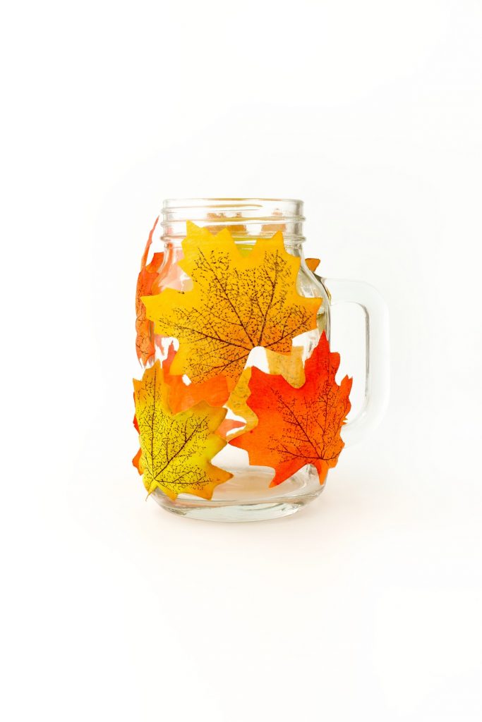 Mason Jar Decorated with Artificial Autumn Leaves on White