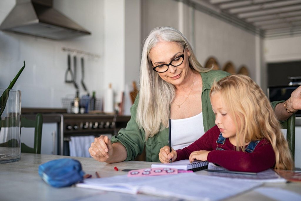 grandmother helping child with homework at home