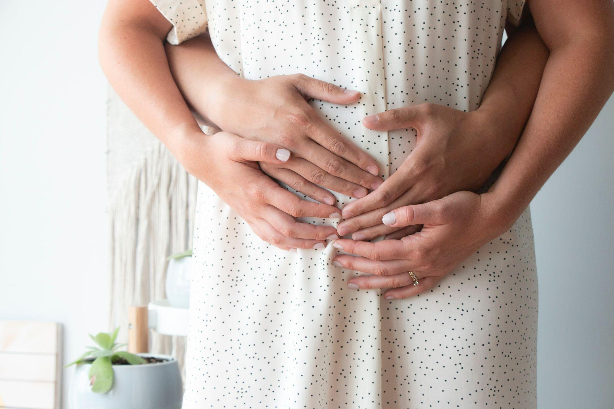Woman and man hands holding pregnancy belly