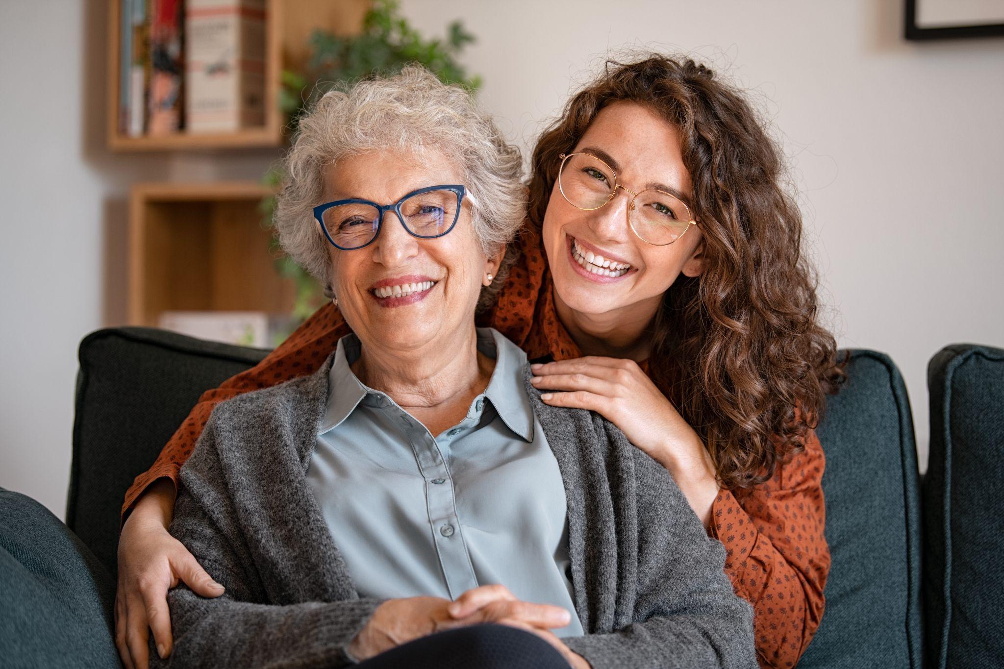 Smiling senior and concierge caregiver at home.